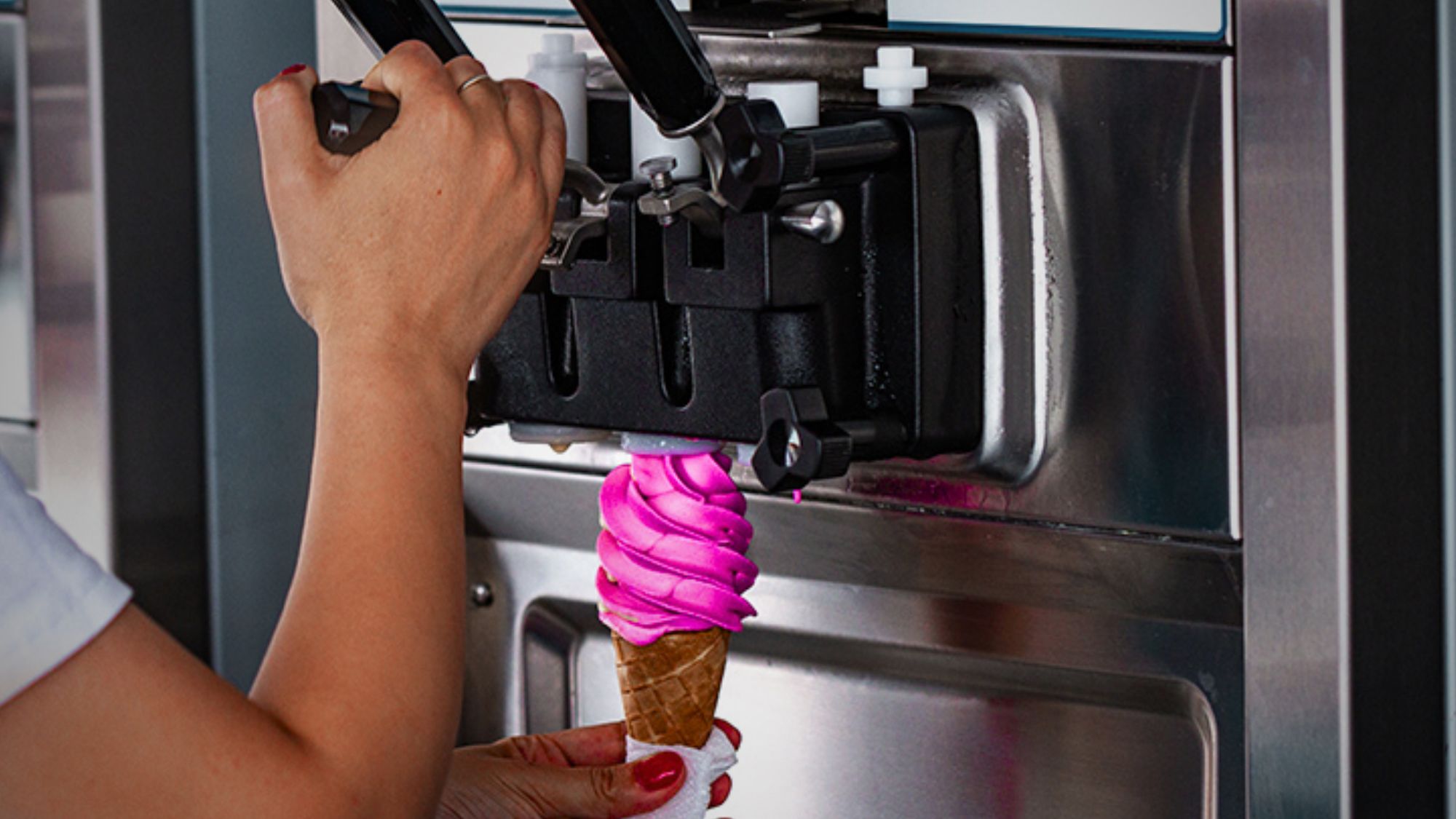 A person getting cone ice cream from Taylormate ice cream machine
