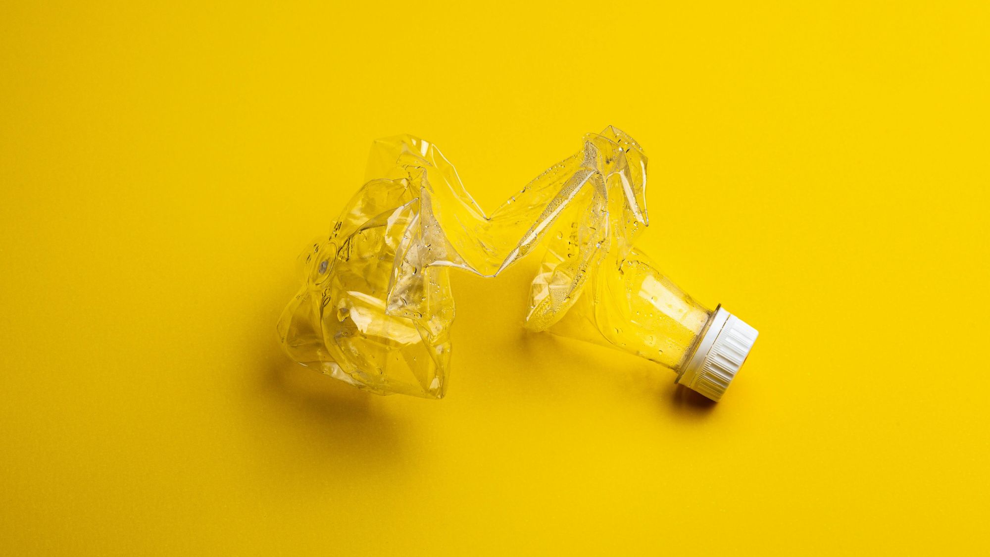 A plastic bottle on a yellow background showcasing waste reduction importance