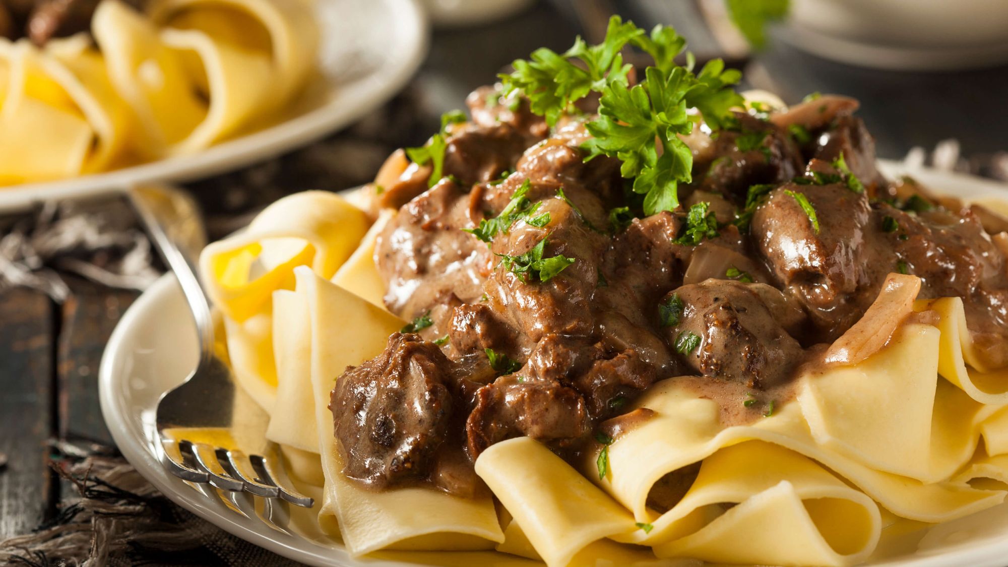 Family members enjoying savory bites of beef stroganoff on a gathering