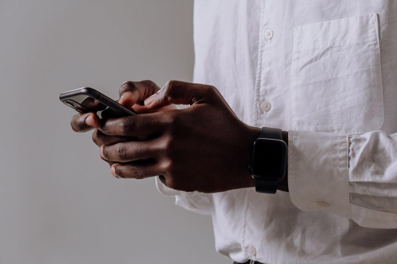 https://www.pexels.com/photo/person-in-white-dress-shirt-holding-black-smartphone-5083010/